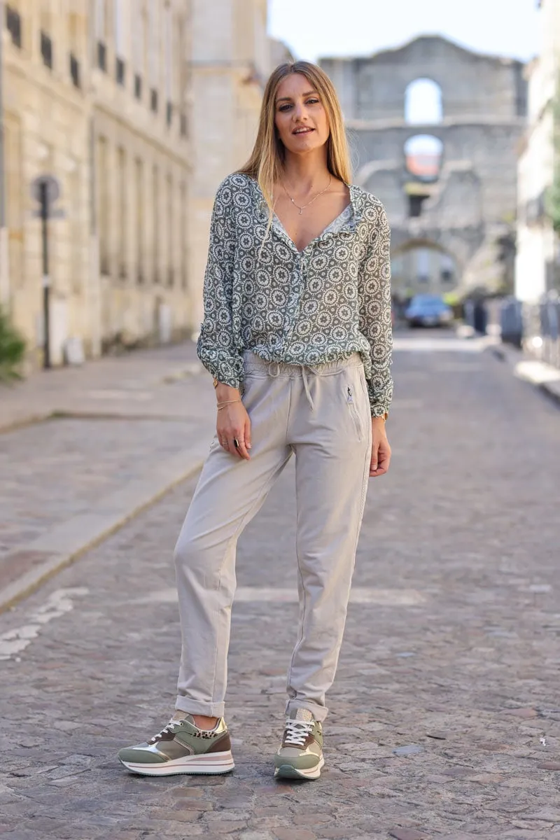 Jogging beige en coton ceinture élastique et poches zips liseré broderie chevrons