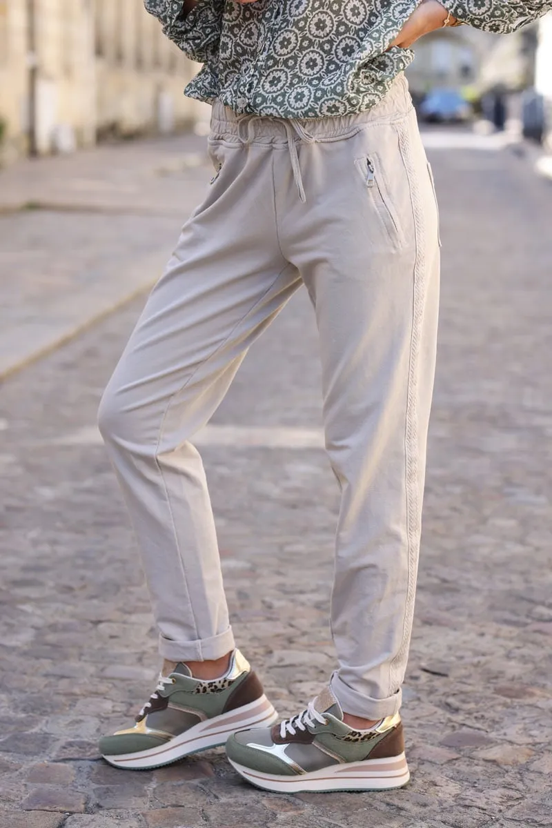 Jogging beige en coton ceinture élastique et poches zips liseré broderie chevrons