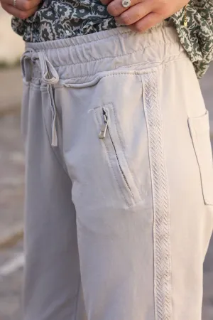 Jogging beige en coton ceinture élastique et poches zips liseré broderie chevrons
