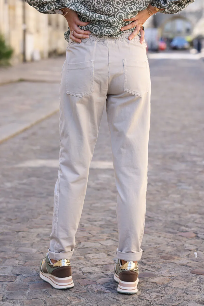 Jogging beige en coton ceinture élastique et poches zips liseré broderie chevrons
